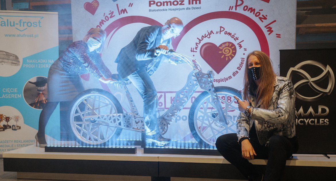 Zdjęcie roweru custumowego i siedzącego obok niego konstruktora