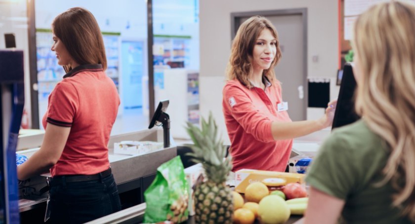 Na zdjęciu, na pierwszym planie, kasjerka w jednym z marketów / Foto: mat. pras.