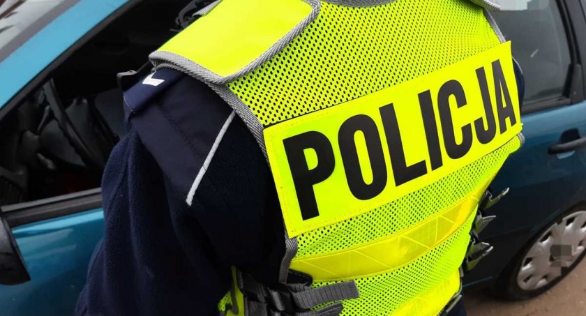 Zdjęcie policjanta z białostockiej patrolówki stojącego bokiem/ podlaska.policja.gov.pl