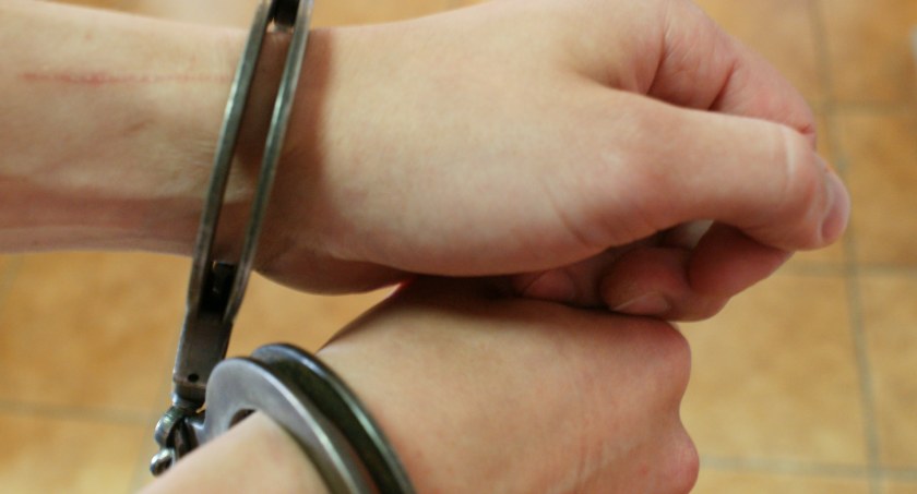 Zdjęcie rąk mężczyzny skutych kajdankami/ podlaska.policja.gov.pl