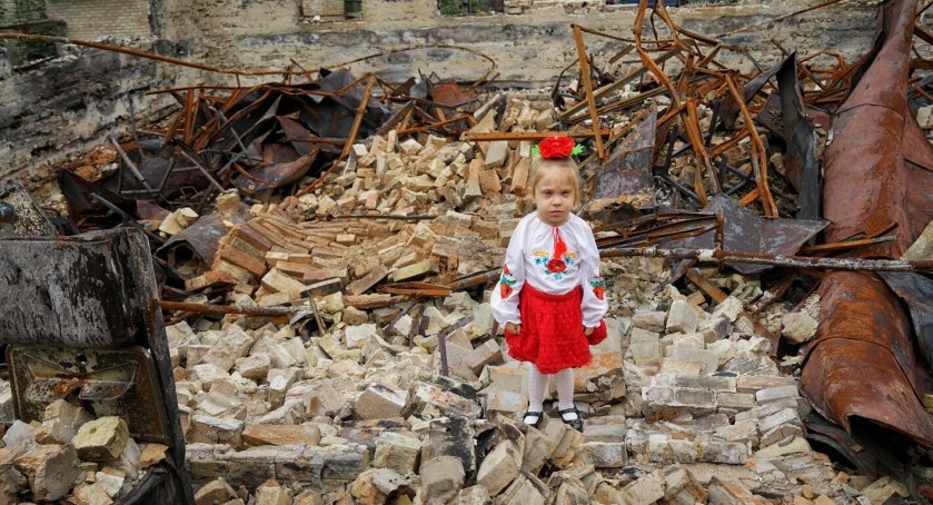 Zdjęcie dziewczynki na zgliszczach zbombardowanego budynku na Ukrainie/ UNICEF