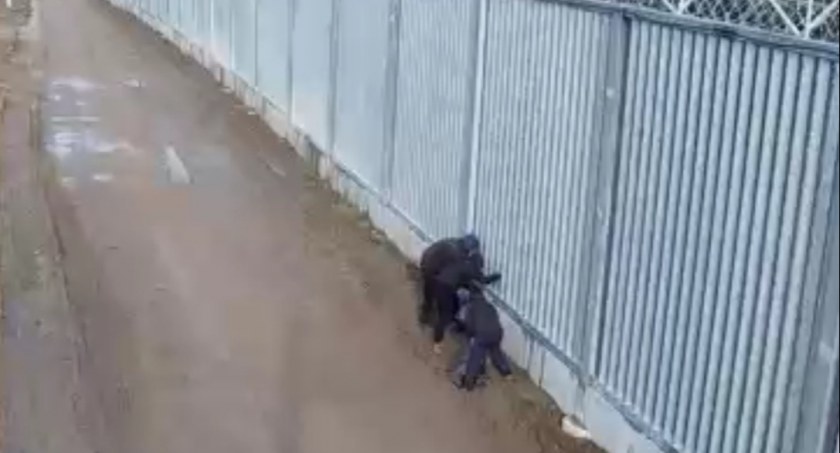 Zdjęcie aktywistów usiłujących przerzucić przedmioty przez zaporę na terytorium Białorusi/ SG