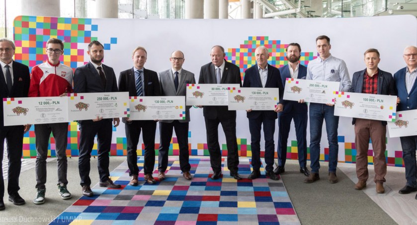 Zdjęcie przedstawicieli stowarzyszeń i klubów sportowych z symbolicznymi czekami/ podlaskie.eu
