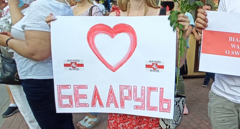 Zdjęcie kobiety trzymającej kartkę z napisem Białoruś/ DDB
