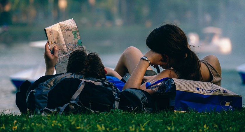 Zdjęcie turystów z mapą leżących na trawie/ PIxabay.com