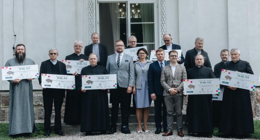 Zdjęcie Marka Malinowskiego z beneficjentami dotacji na remont zabytków/ podlaskie.eu