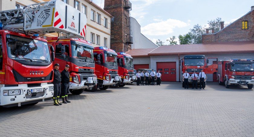 Zdjęcie strażaków przy wozach strażackich/ PUW