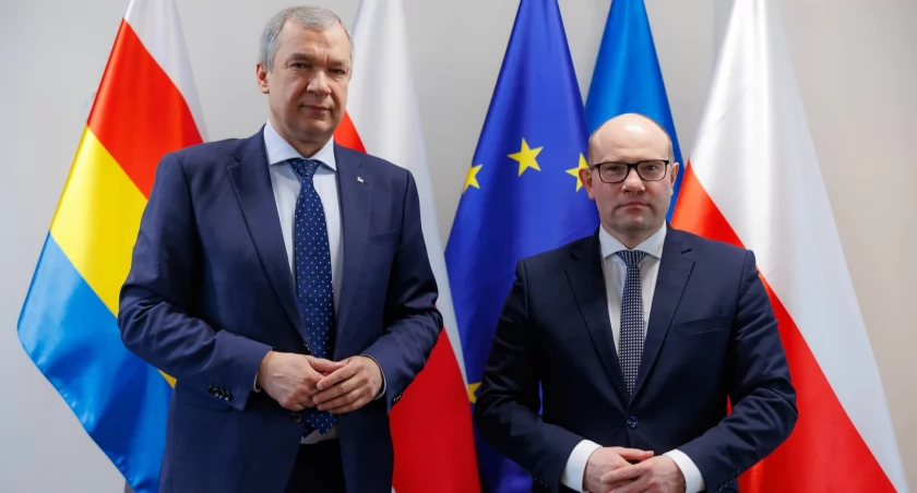 Zdjęcie Pawła Łatuszki i Artura Kosickiego na tle flag/ podlaskie.eu