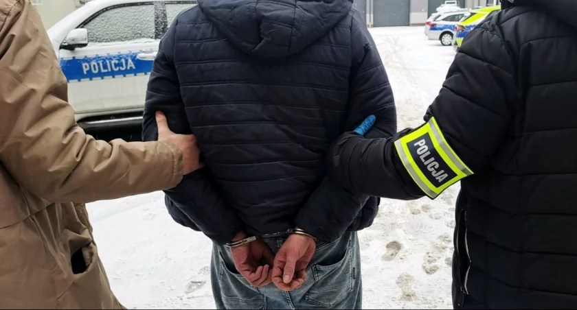 Zdjęcie zatrzymanego mężczyzny prowadzonego przez policjantów/ podlaska.policja.gov.pl