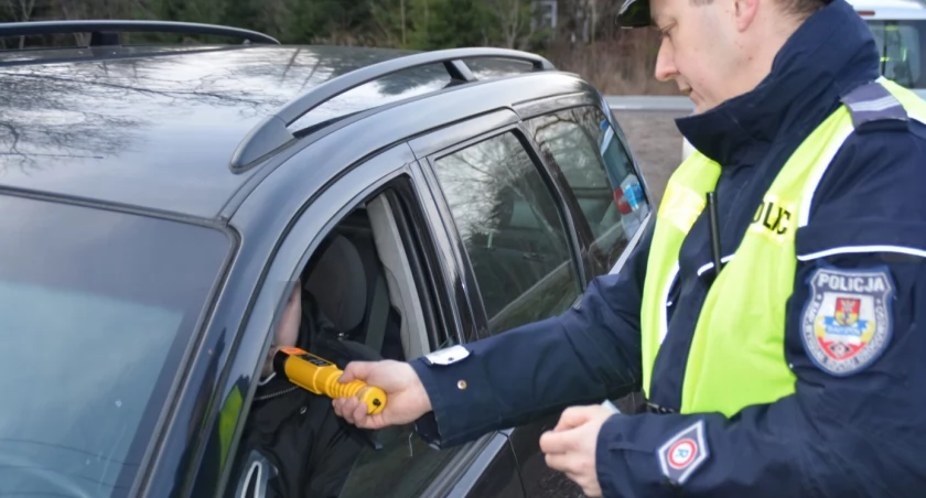 Zdjęcie policjanta trzymającego urządzenie do pomiaru alkoholu w wydychanym powietrzu/ podlaska.policja.gov.pl