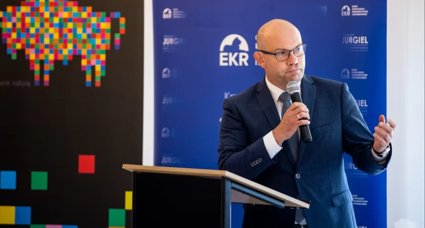 Zdjęcie marszałka Artura Kosickiego na tle flag/ podlaskie.eu