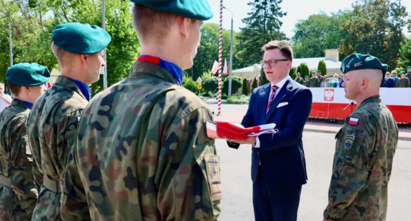 Zdjęcie Szymona Hołowni przekazującego flagę żołnierzom/ Piotr Molęcki Kancelaria Sejmu