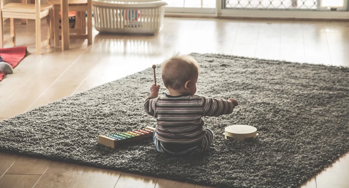 Zdjęcie dziecka bawiącego się na dywanie/ Pixabay.com music