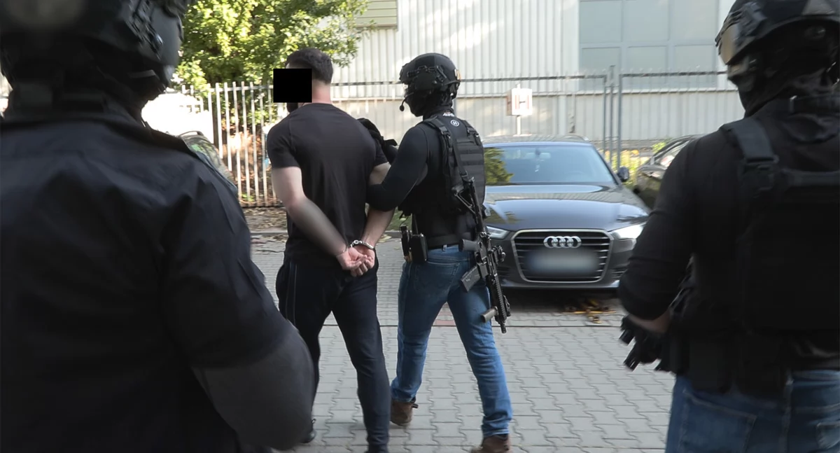 Zdjęcie zatrzymanego mężczyzny prowadzonego przez policjantów/ podlaska.policja.gov.pl