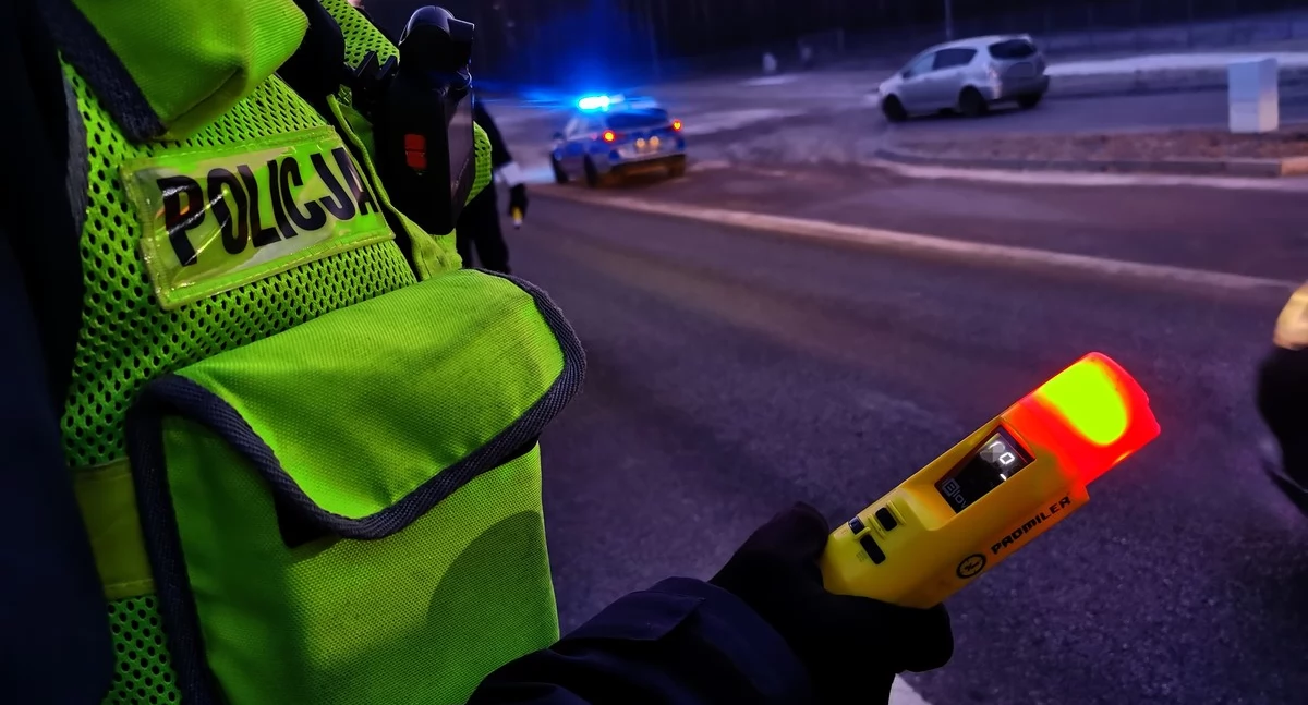 Zdjęcie policjanta sprawdzającego trzeźwość kierowcy/ podlaska.policja.gov.pl