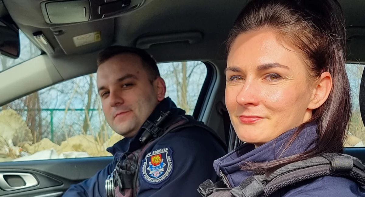 Zdjęcie policyjnej pary w radiowozie/ podlaska.policja.gov.pl