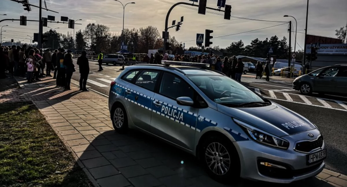 Zdjęcie policyjnego radiowozu i policjanta kierującego ruchem przy cmentarzu w Białymstoku/ podlaska.policja.gov.pl