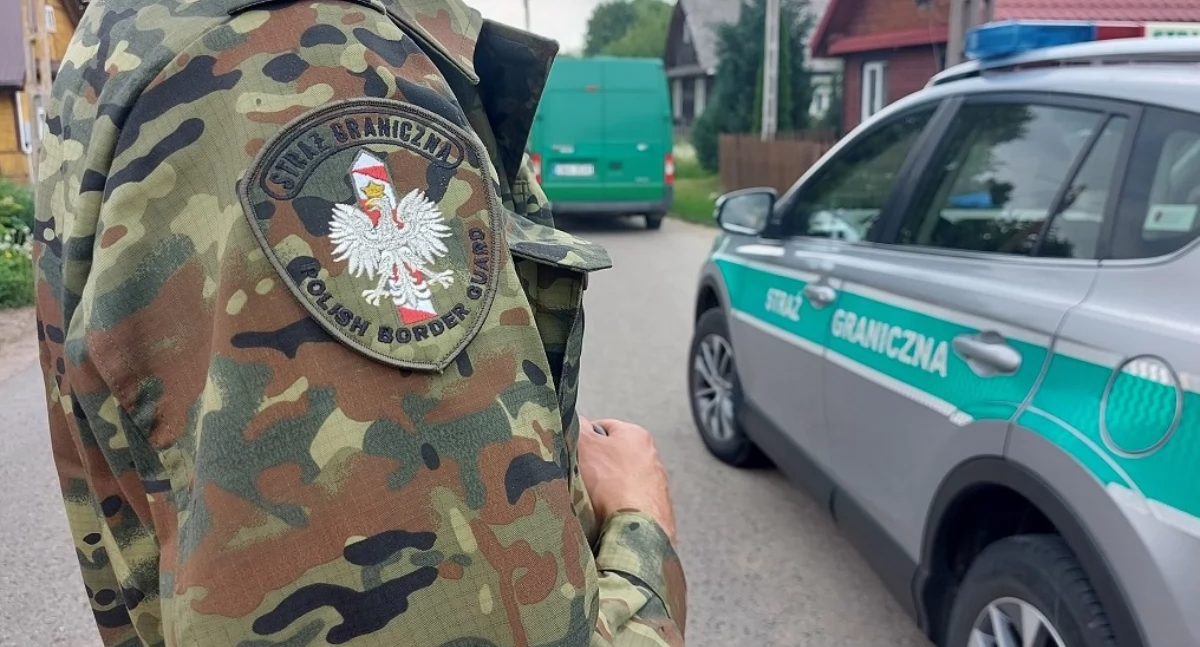 Zdjęcie strażnika granicznego przy pojeździe służbowym/ SG