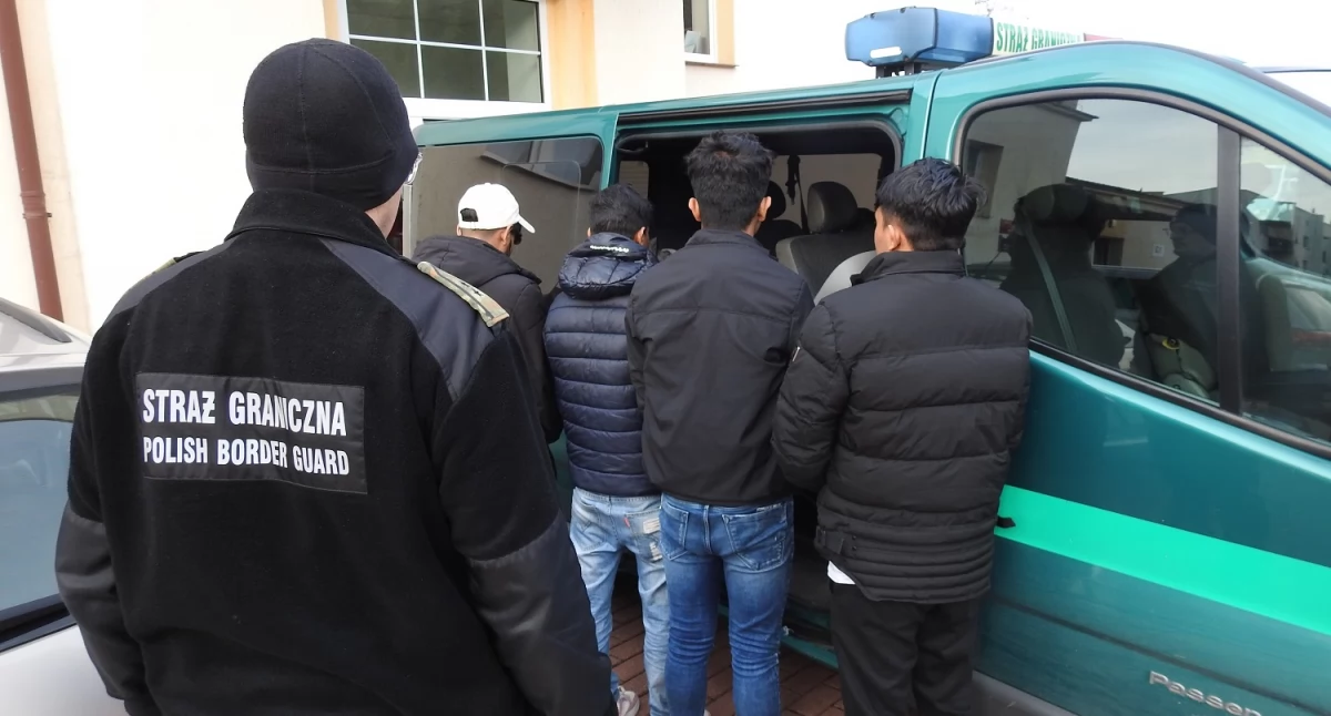 Zdjęcie strażników granicznych z zatrzymanymi nielegalnymi migrantami/ SG