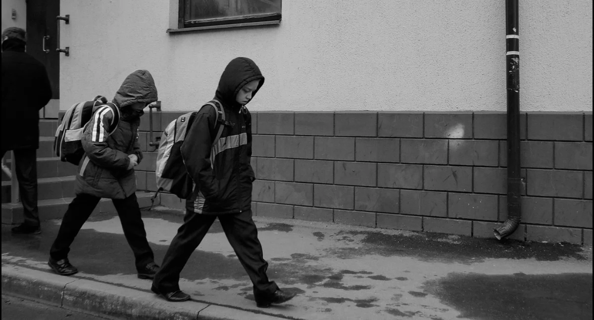 Zdjęcie dzieci z plecakami idących chodnikiem/ Flickr.com/ photopehota
