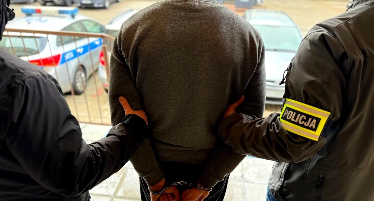 Zdjęcie policjantów prowadzących zatrzymanego mężczyznę/ podlaska.policja.gov.pl