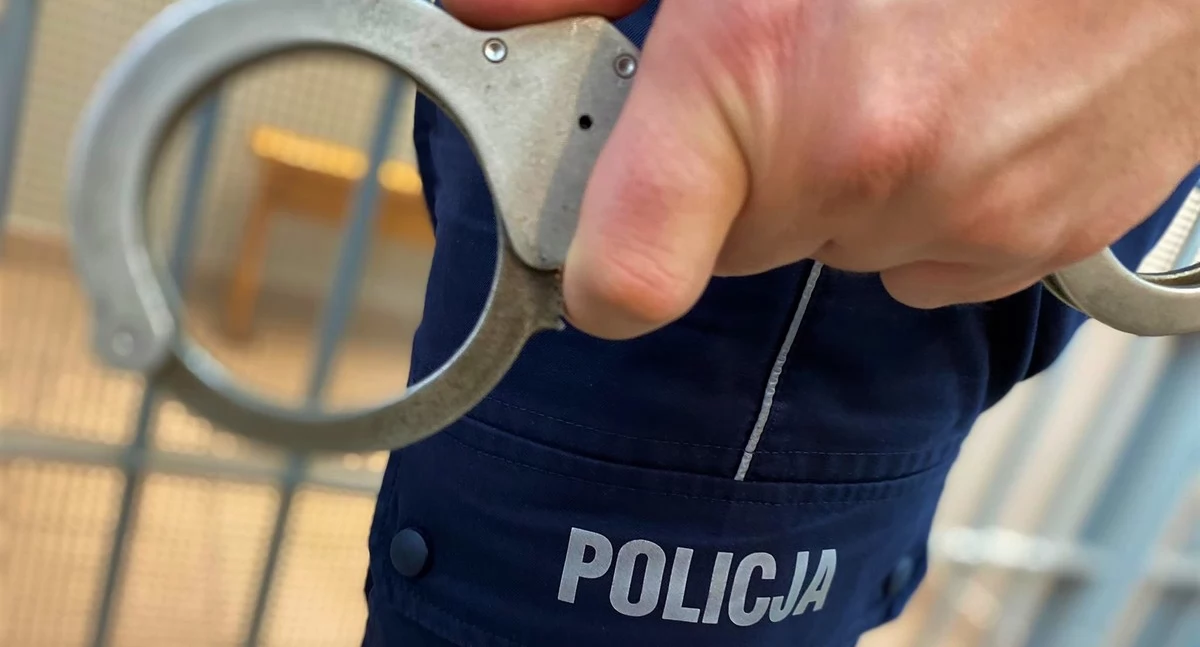 Zdjęcie policjanta trzymającego kajdanki/ podlaska.policja.gov.pl