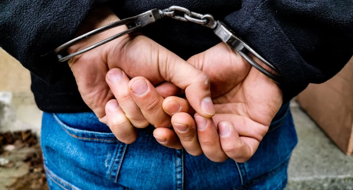 Zdjęcie rąk mężczyzny w kajdankach/ podlaska.policja.gov.pl