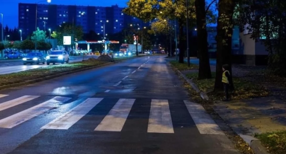 Zdjęcie dziecka w kamizelce odblaskowej na przejściu dla pieszych/ UM w Łapach