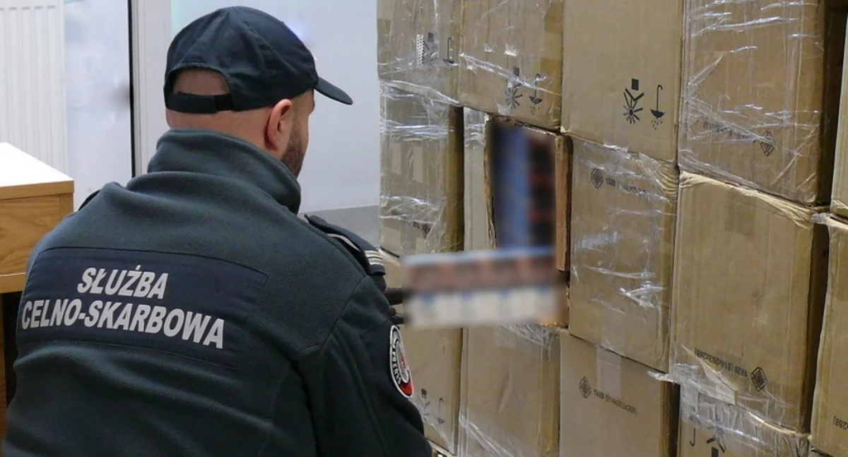 Zdjęcie funkcjonariusza KAS z zarekwirowaną kontrabandą papierosową/ KAS
