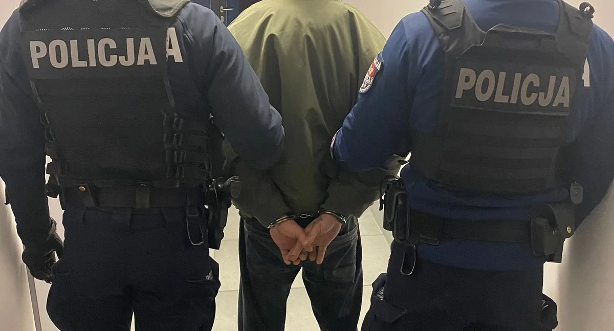 Zdjęcie policjantów prowadzących zatrzymanego mężczyznę/ podlaska.policja.gov.pl