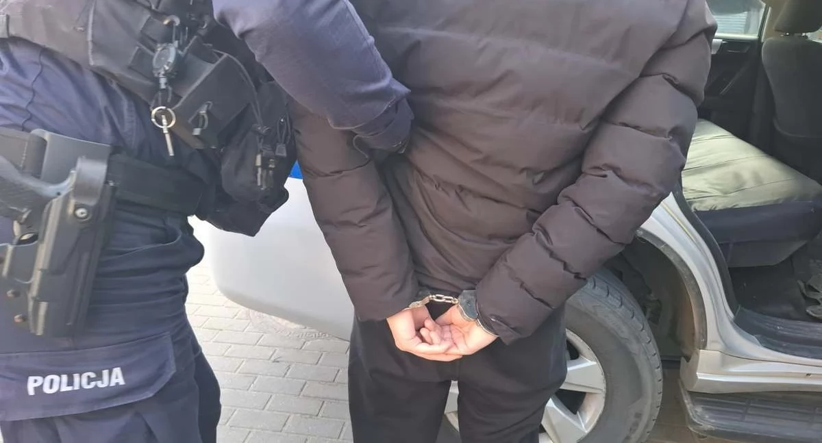 Zdjęcie policjanta prowadzącego zatrzymanego mężczyznę/ podlaska.policja.gov.pl