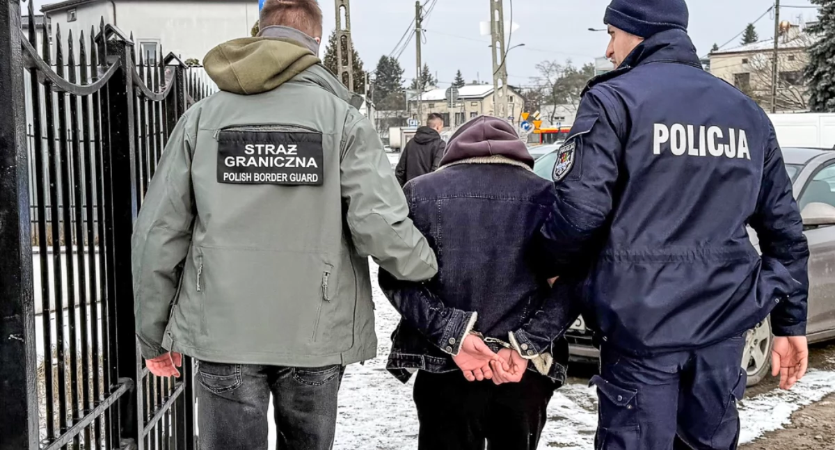 Zdjęcie policjanta i strażnika granicznego prowadzących zatrzymanego mężczyznę/ SG