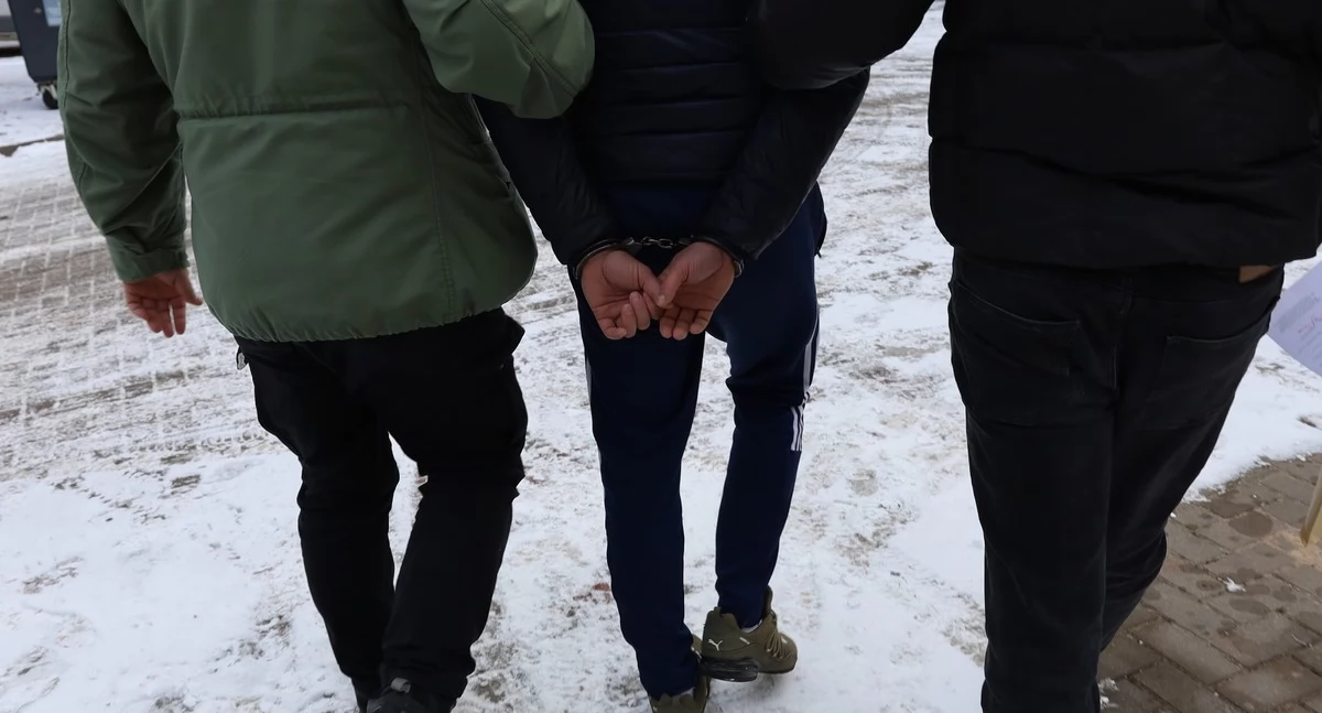 Zdjęcie policjantów prowadzących zatrzymanego mężczyznę/ podlaska.policja.gov.pl