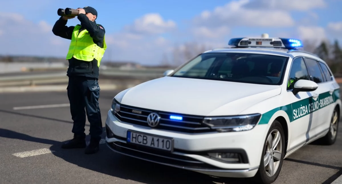 Zdjęcie celnika przy pojeździe służbowym patrolującego teren/ KAS
