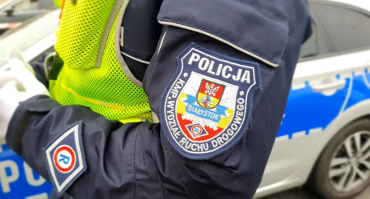 Zdjęcie policjanta przy radiowozie/ podlaska.policja.gov.pl