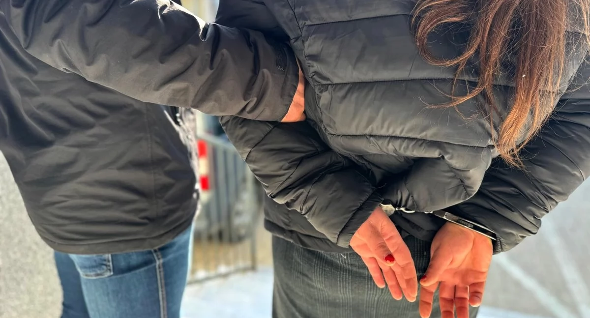 Zdjęcie policjanta prowadzącego zatrzymaną kobietę/ podlaska.policja.gov.pl