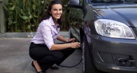 Frau füllt Autoreifen auf
